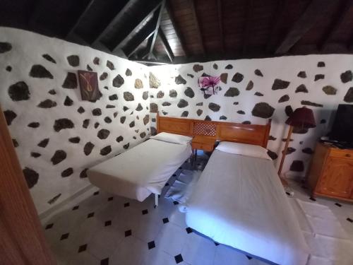 a room with two beds in a room with a wall at La Carpintera in Tijarafe