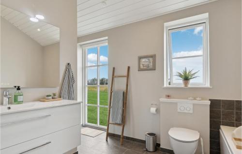 baño con aseo y lavabo y ventana en Stunning Home In Lkken With Sauna, en Løkken