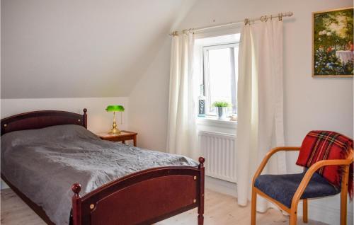 a bedroom with a bed and a chair and a window at Cozy Home In Sankt Ibb With Wifi in Sankt Ibb
