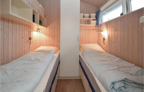 two beds in a small room with wooden walls at Awesome Home In Vejers Strand With 1 Bedrooms And Wifi in Vejers Strand