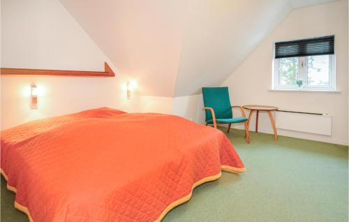 ブラーバンドにあるGorgeous Home In Blvand With Wifiのベッドルーム1室(オレンジ色のベッド1台、椅子、テーブル付)