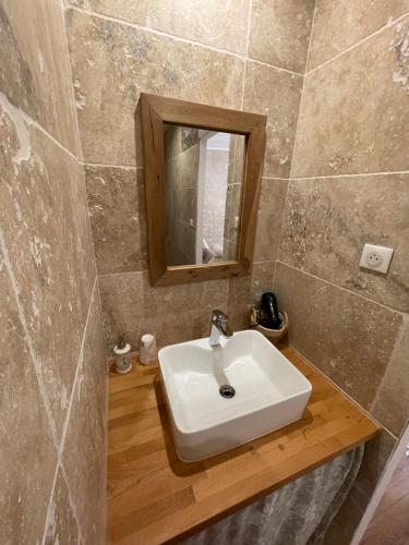 a bathroom with a white sink and a mirror at La Bohème in Condom