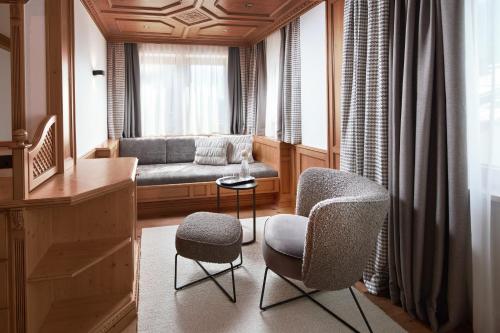 a living room with a couch and chairs and a window at Hotel Gletscherblick in Sankt Anton am Arlberg