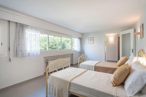 une chambre avec deux lits et une fenêtre dans l'établissement Dream Villa 300m2 & stunning 4000m2 private garden, à Cannes