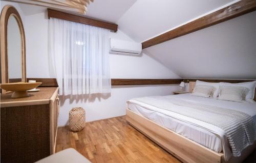 a bedroom with a bed and a sink and a mirror at Awesome Home In Rokovci With Outdoor Swimming Pool 