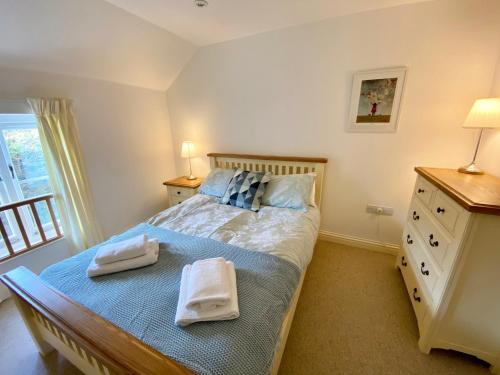 a bedroom with a bed with towels on it at Florabil in Sidbury