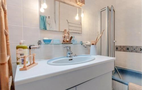 La salle de bains blanche est pourvue d'un lavabo et d'un miroir. dans l'établissement Cozy Home In Saint-georges-de-didon With Kitchen, à Saint-Georges-de-Didonne