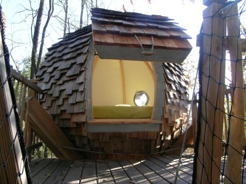 une cabane dans les arbres avec un lit au milieu dans l'établissement Chambres d'hôtes Ptits Déj inclus - Salle d'eau tout à vous - Parking Privé Gratuit - Centre ville Bergerac 5km - Domaine de Bellevue Cottage en Périgord, à Lembras