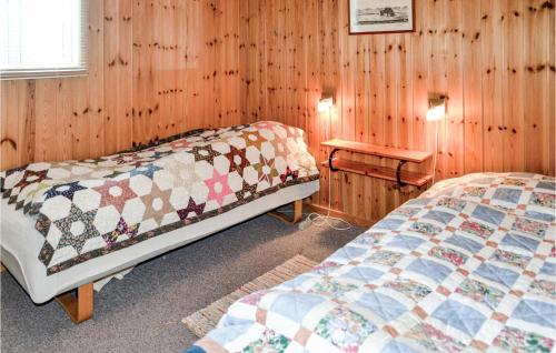 バイアス・スタンにある3 Bedroom Cozy Home In Vejers Strandのベッド2台 木製の壁の部屋