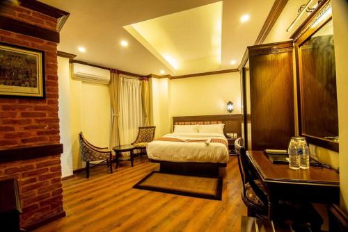 Habitación de hotel con cama, escritorio y escritorio. en Pashupati Boutique Hotel & Spa en Katmandú