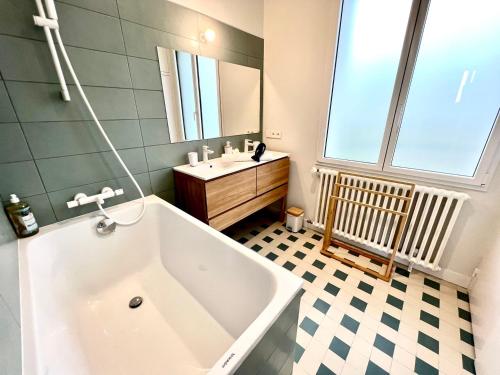 een badkamer met een bad en een wastafel bij La Villa Océane, Elegante, Plages, GR34, 2-8 pers in Clohars-Carnoët