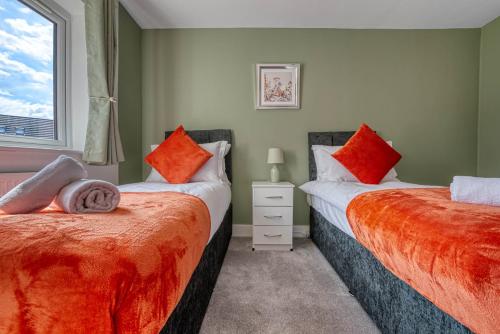 two beds sitting next to each other in a bedroom at Luxurious Birmingham Home Private Parking WiFi - near to NEC and QEH in Longbridge