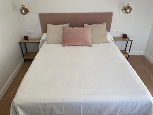 duże białe łóżko z 2 stolikami nocnymi w obiekcie Apartamento Loft Jerez Bulería w mieście Jerez de la Frontera