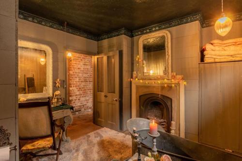 a living room with a fireplace and a candle at Seasoned Grandeur Home in Faversham