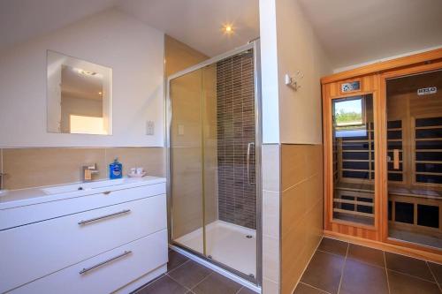 a bathroom with a shower and a sink at Locholly Lodge in Achiltibuie