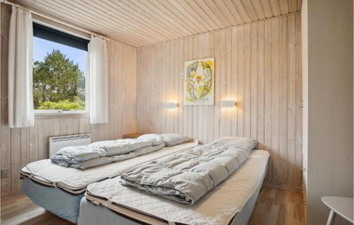 BjerregårdにあるBeautiful Home In Hvide Sande With Wifiの窓付きの客室で、ベッド2台が備わります。