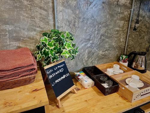 a table with a potted plant and a sign on it at La moon in Ban Pa Tung (7)