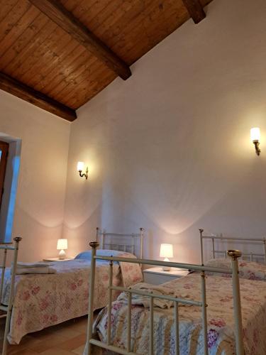 - une chambre avec deux lits et deux lumières sur le mur dans l'établissement Agriturismo Murera, à Acquapendente