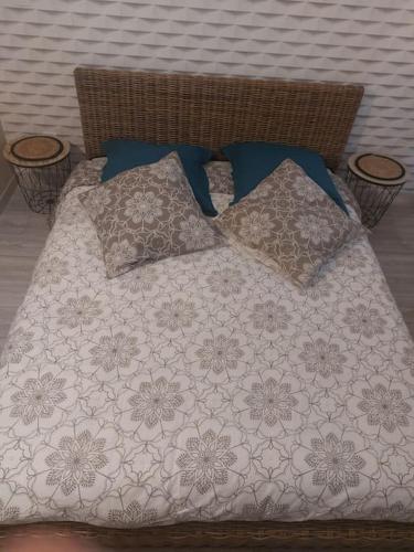 - un lit avec une couverture et des oreillers dans l'établissement gîte au cœur des châteaux, à Monteaux