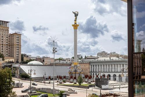 a view of a city with a statue in the middle at Maidan Palace Hotel in Kyiv