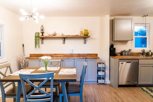 a kitchen with a wooden table and blue chairs at Madrona's Guesthouse- Convenient location, pet friendly in Charleston