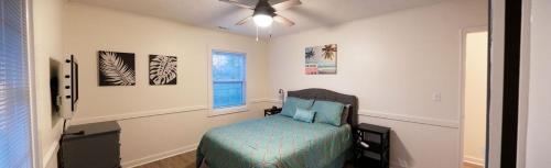 チャールストンにあるMadrona's Guesthouse- Convenient location, pet friendlyのベッドと天井扇風機のある寝室