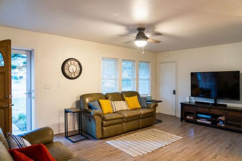 a living room with a couch and a flat screen tv at Madrona's Guesthouse- Convenient location, pet friendly in Charleston