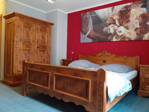 a bedroom with a wooden bed and a painting on the wall at Hotel das rot in Burgkunstadt