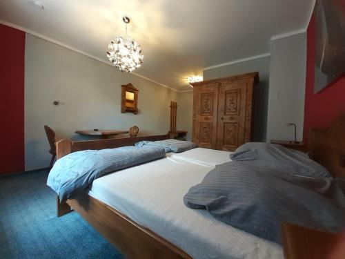 a bedroom with a large bed and a chandelier at Hotel das rot in Burgkunstadt