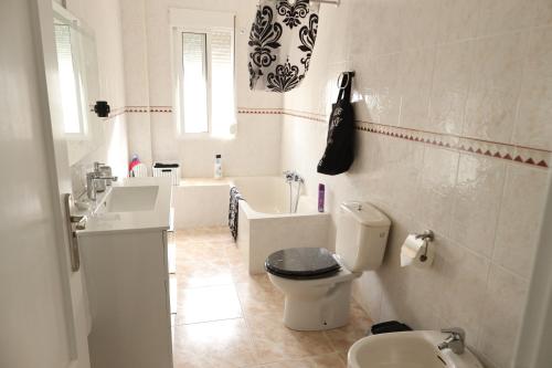 a bathroom with a toilet and a sink and a tub at The Dream Holiday Room in Belicena