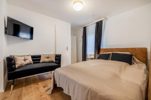 a bedroom with a large bed and a chair at Mama Home Apartment W26 in St. Gallen