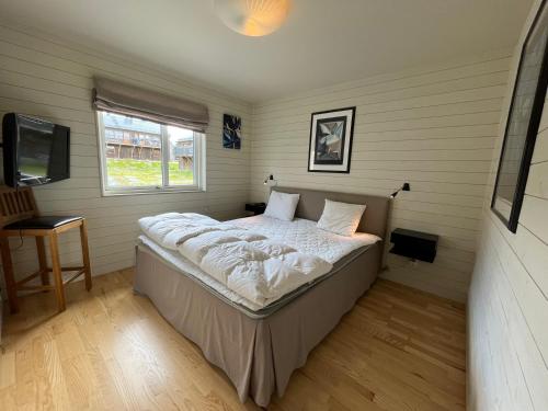 a bed in a room with a window and a television at Ski Village Funäsdalen in Funäsdalen