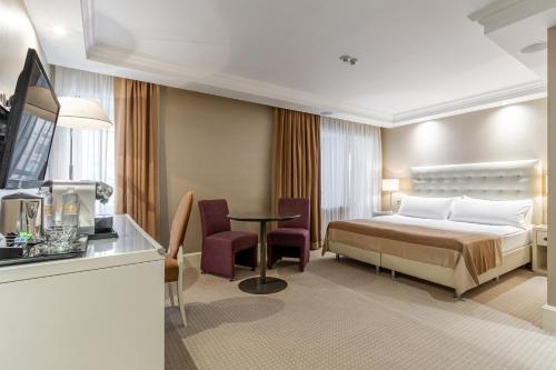 a hotel room with a bed and a table at Maidan Palace Hotel in Kyiv