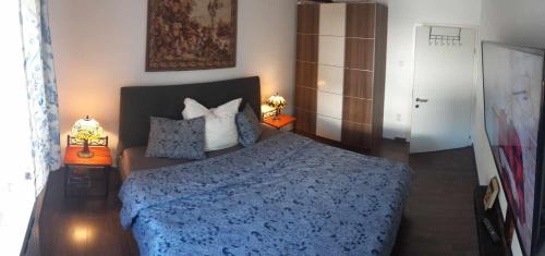1 dormitorio con 1 cama azul y 2 lámparas en Zu Hause am Bach, en Aggsbach