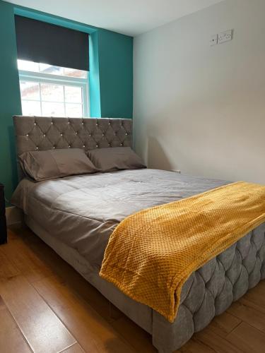 een bed met een deken erop in een slaapkamer bij Cairo Street in Warrington