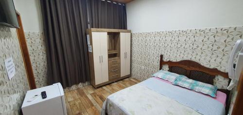 a bedroom with a bed and a dresser in it at Casa aconchegante com WiFi Governador Valadares MG in Governador Valadares