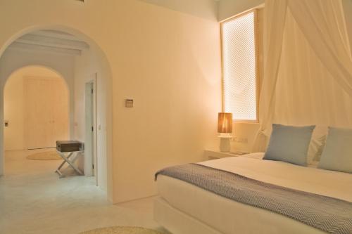 a white bedroom with a bed and a window at Octant Vila Monte in Moncarapacho
