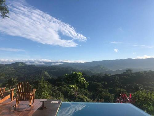 a swimming pool with a chair and a view of the mountains at Luxury Villa Carao - Serene Amazing Views at Finca Chilanga in San Mateo