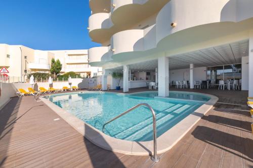 a swimming pool in the middle of a building at AlvorMar Apartamentos Turisticos in Alvor