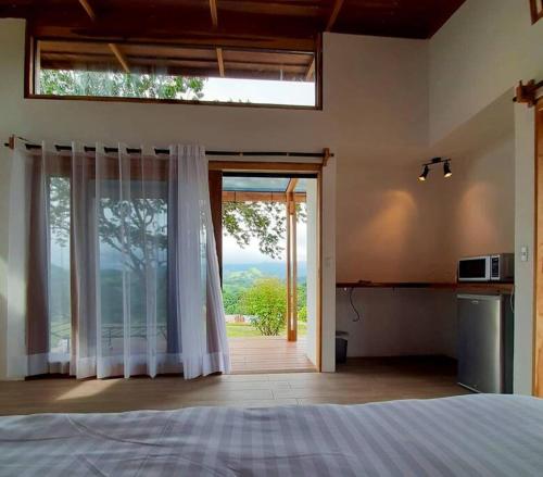 a bedroom with a large glass door with a window at Luxury Villa Carao - Serene Amazing Views at Finca Chilanga in San Mateo