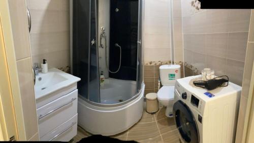 y baño con ducha, aseo y lavamanos. en Nur 5, en Uralsk