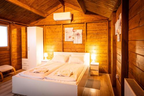 a bedroom with a bed in a wooden room at Agamim in Mikołajki