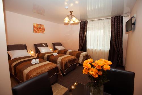 um quarto com duas camas e uma mesa com flores em Apartamentai Vyta em Klaipėda