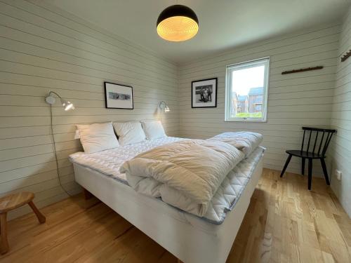 a bedroom with a bed with a white comforter at Ski Village Funäsdalen in Funäsdalen