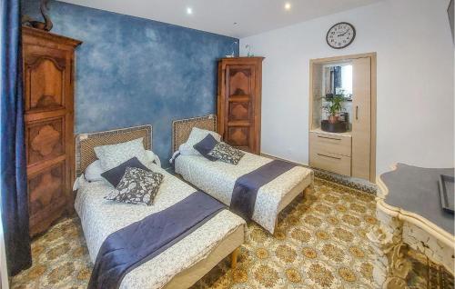 een slaapkamer met 2 bedden en een klok aan de muur bij Nice Home In Bucquoy With Kitchen 