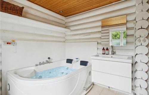 Baño blanco con bañera y lavamanos en Stunning Home In Stege With Wifi, en Pollerup Kullegård