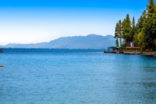 a large body of water with a pier and mountains at Lazy K on Peaceful Bay - Full Property in Lakeside