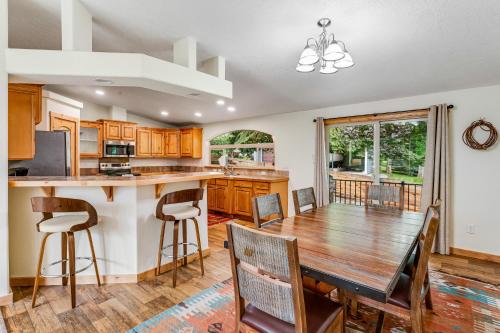 a kitchen and dining room with a wooden table and chairs at Lazy K on Peaceful Bay - Full Property in Lakeside