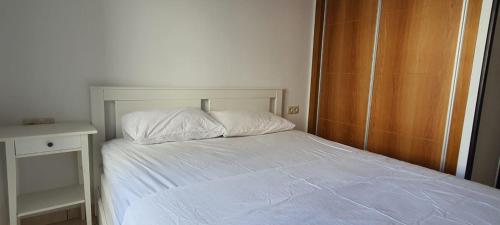 een slaapkamer met een wit bed en een houten kast bij Urban corner in Tetouan
