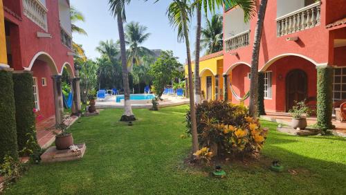 un cortile di una casa con palme e anatre nell'erba di Casa Colonial, Cozumel Villa Indigo a Cozumel